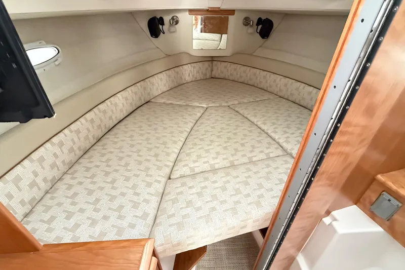 Slide: The Image of 2026 Cutwater C-248 Coupe interior cabin with cushioned V-berth and wooden accents. - 43