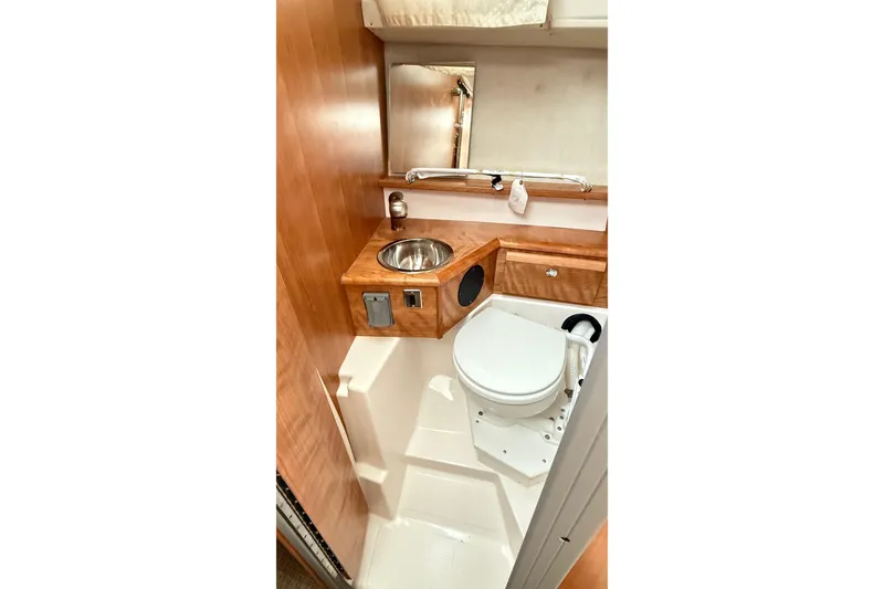 Slide: The Image of 2026 Cutwater C-248 Coupe bathroom with compact sink, toilet, and wooden cabinetry. - 46