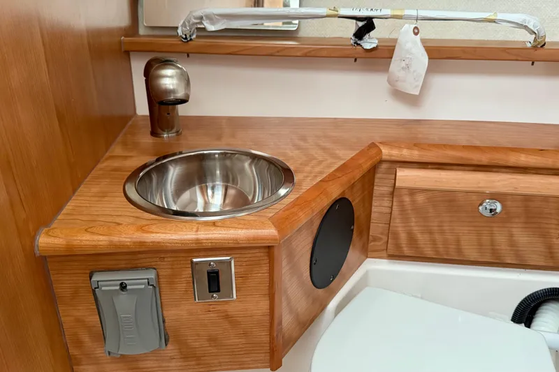 Slide: The Image of 2026 Cutwater C-248 Coupe interior with wooden cabinetry and stainless steel sink. - 50
