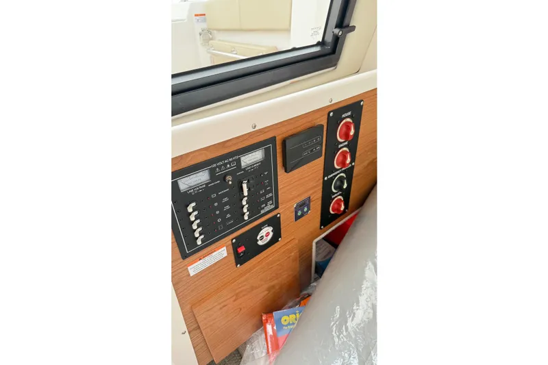 Slide: The Image of 2026 Cutwater C-248 Coupe control panel with switches and gauges, featuring a wood finish. - 59