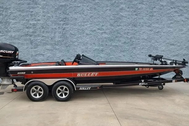 The Image of 2016 Bullet 21XRD boat with Mercury engine on trailer, parked against a gray wall. - 1