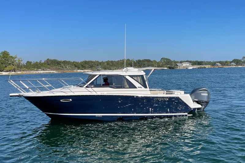 Slide: The Image of 2026 Cutwater C-248 Coupe boat on calm water, clear blue sky background. - 2