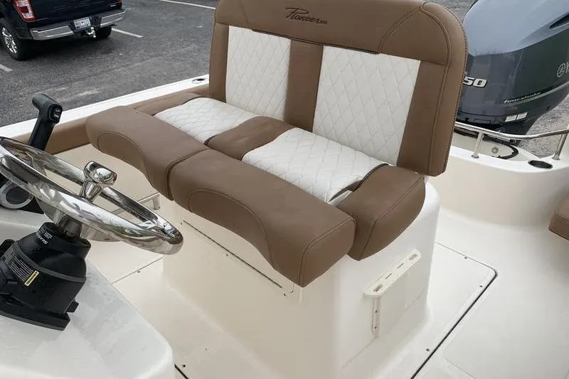 Slide: The Image of 2025 Pionee Sportfish 222 boat interior with brown and white seating and steering wheel. - 15