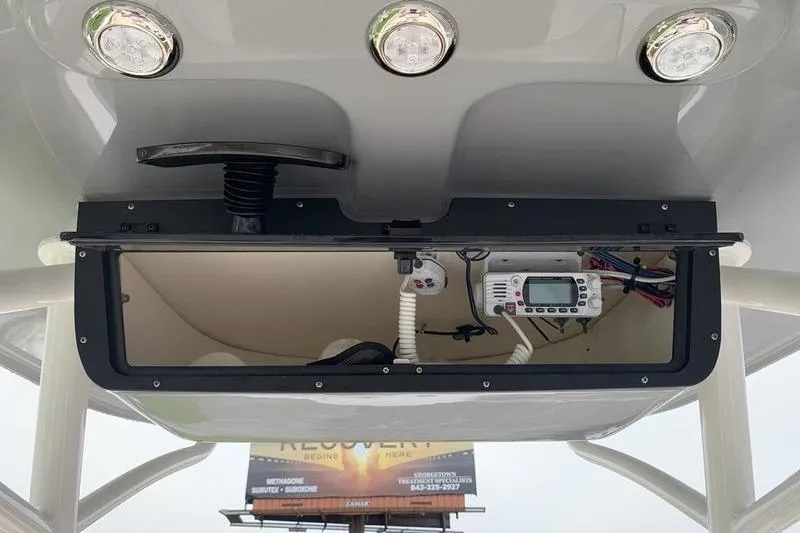 Slide: The Image of 2025 Pionee Sportfish 222 boat console with electronic equipment and overhead lights. - 19