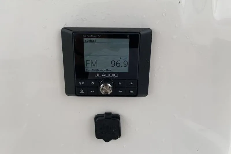 Slide: The Image of JL Audio MediaMaster 50 on Pionee Sportfish 222, 2025 model, displaying FM 96.9. - 21