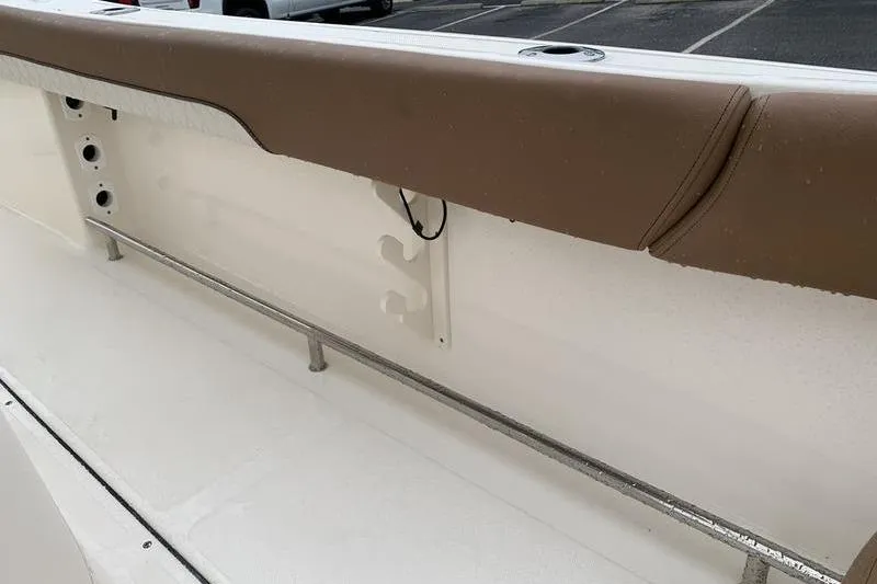 Slide: The Image of 2025 Pionee Sportfish 222 boat interior with brown cushioned rail and rod holders. - 25