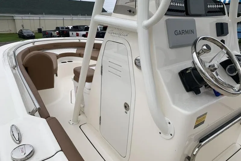Slide: The Image of 2025 Pionee Sportfish 222 boat interior with Garmin navigation system and seating area. - 27