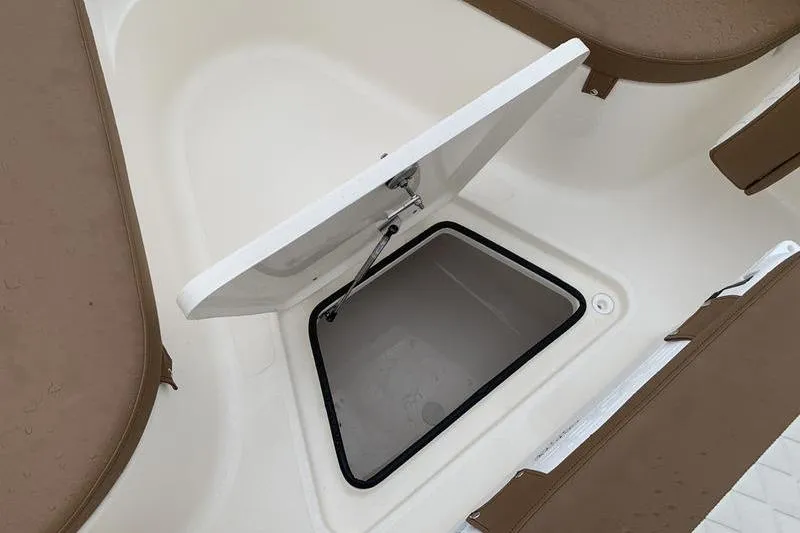 Slide: The Image of Open storage compartment on 2025 Pionee Sportfish 222 boat, featuring brown seating. - 31
