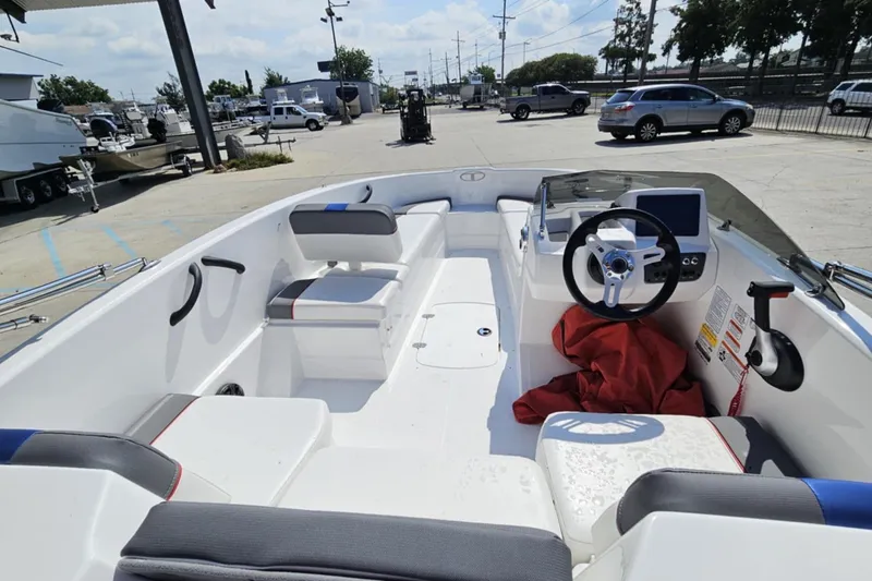 Slide: The Image of 2024 Tahoe T16 boat interior with steering wheel and seating in a marina setting. - 10