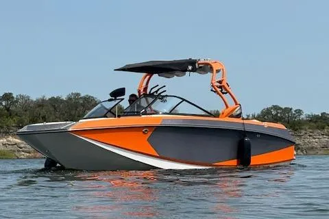 Slide: The Image of 2013 Nautique Super Air Nautique G23 boat on water, orange and gray design. - 0