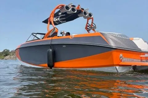 Slide: The Image of 2013 Nautique Super Air Nautique G23 boat on water, featuring orange and gray design. - 4