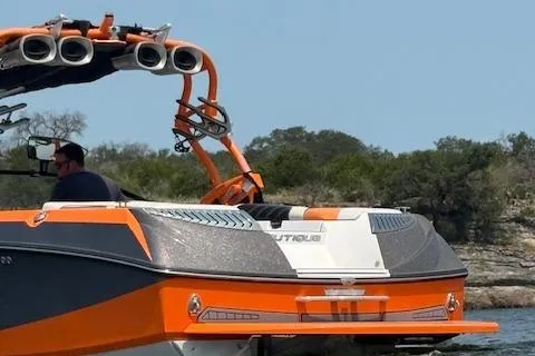 Slide: The Image of 2013 Nautique Super Air Nautique G23 boat on water, featuring orange and gray design. - 6
