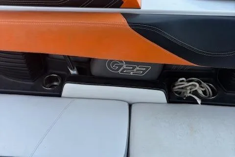 Slide: The Image of 2013 Nautique Super Air Nautique G23 interior with orange and black accents, rope storage. - 7