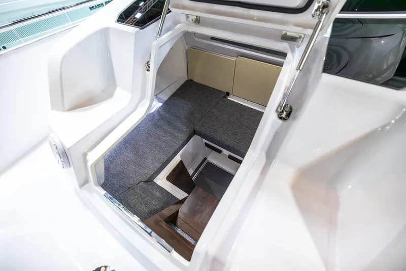 Slide: The Image of 2025 Axopar Sun-Top boat interior with gray seating and table, docked by wooden pier. - 25