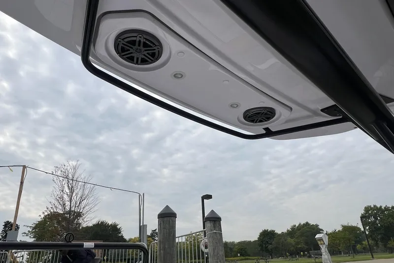 Slide: The Image of 2025 Axopar Sun-Top boat speakers and canopy against cloudy sky. - 31