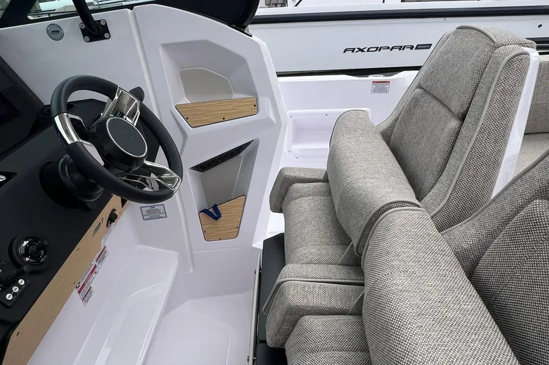Slide: The Image of 2025 Axopar Sun-Top boat interior with steering wheel and cushioned seats. - 36
