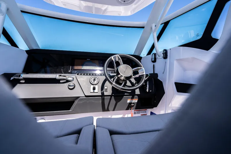 Slide: The Image of 2025 Axopar Sun-Top boat interior with cushioned seating and a sleek white table. - 7