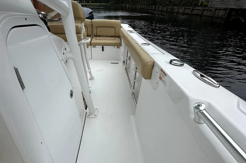 Slide: The Image of 2021 Sportsman Heritage 231 Center Console boat interior with beige seating and white deck. - 12