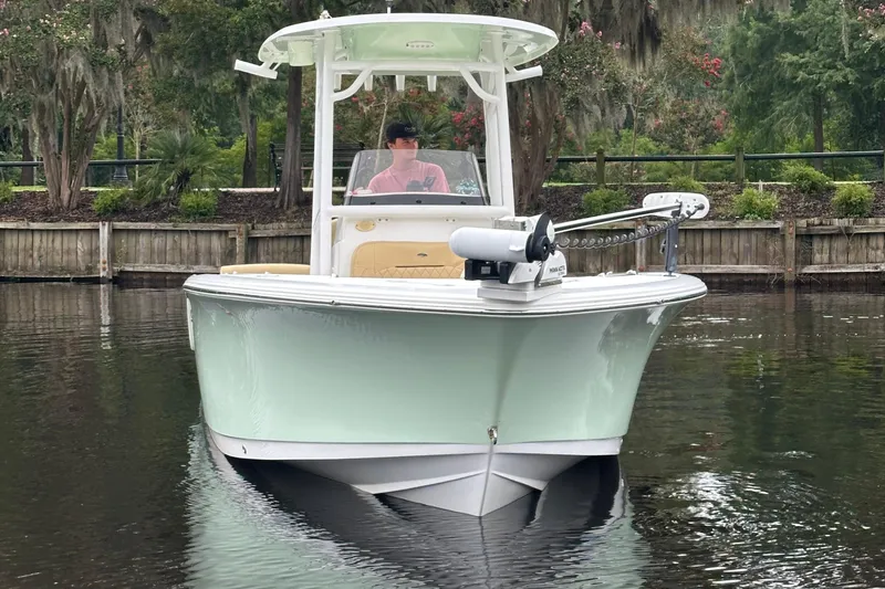 Slide: The Image of 2021 Sportsman Heritage 231 Center Console boat on calm water, surrounded by lush greenery. - 17