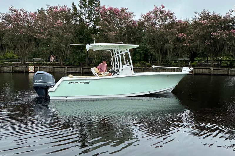 Slide: The Image of 2021 Sportsman Heritage 231 Center Console boat on calm water, surrounded by trees. - 22