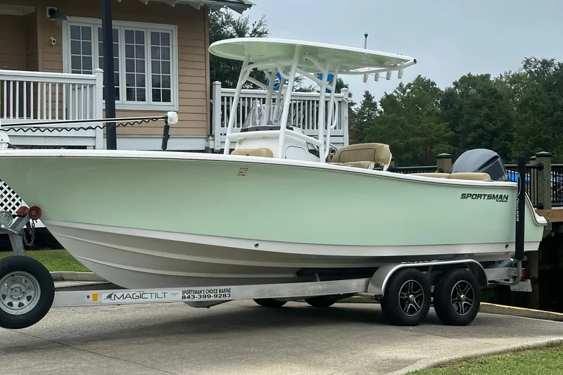 Slide: The Image of 2021 Sportsman Heritage 231 Center Console boat on trailer near house. - 23