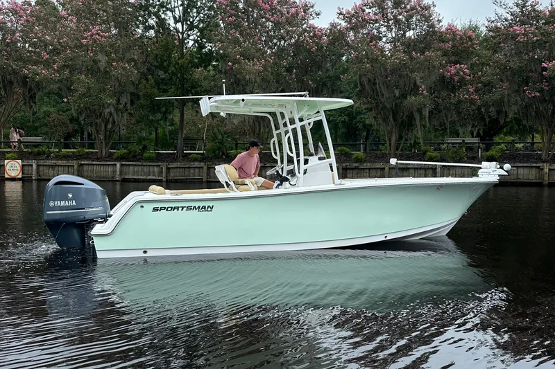 Slide: The Image of 2021 Sportsman Heritage 231 Center Console boat on calm water, surrounded by trees. - 3