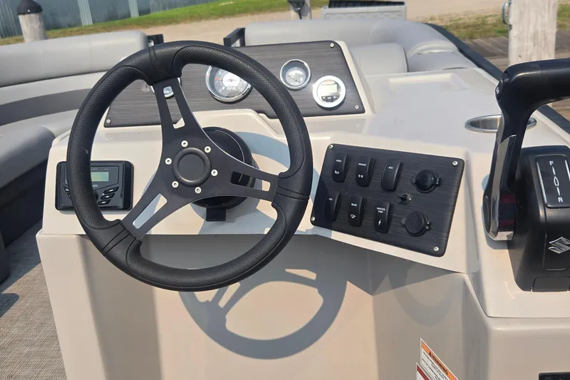 Slide: The Image of Steering console of 2022 Flagship Pontoon E22CU with controls and gauges. - 2