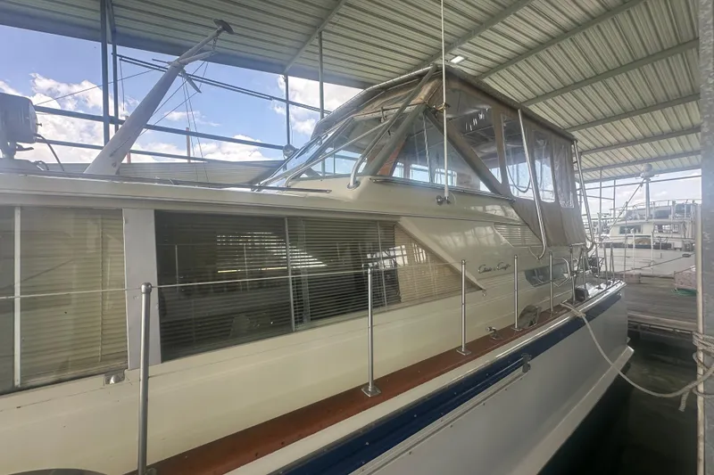 Slide: The Image of 1971 Chris-Craft Commander 42 yacht docked under a covered marina. - 11