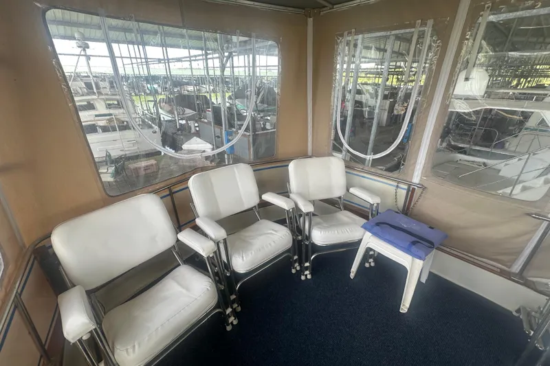 Slide: The Image of 1971 Chris-Craft Commander 42 interior with white chairs and windows in a marina setting. - 15