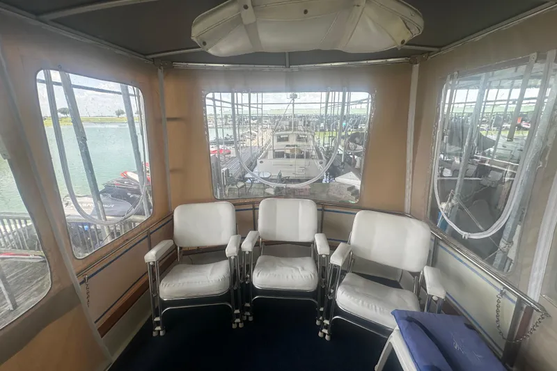 Slide: The Image of 1971 Chris-Craft Commander 42 interior with white chairs and marina view. - 16