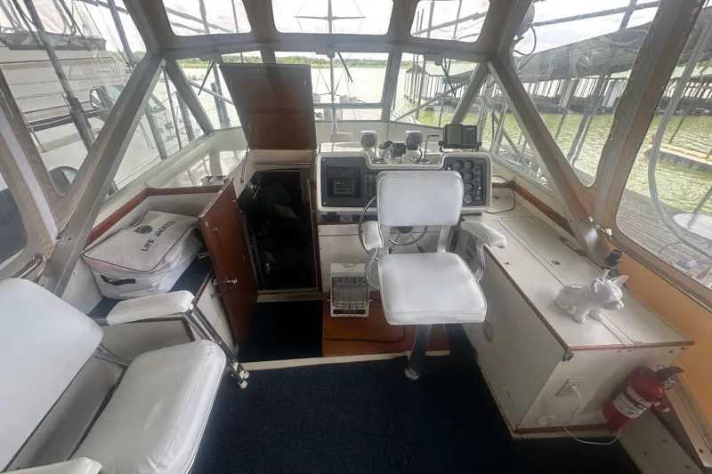Slide: The Image of 1971 Chris-Craft Commander 42 cockpit with helm, white seating, and navigation instruments. - 17