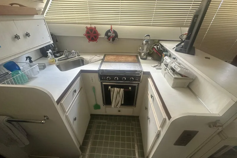 Slide: The Image of 1971 Chris-Craft Commander 42 kitchen with stove, sink, and storage cabinets. - 28