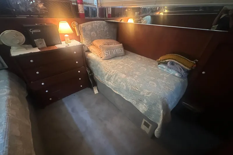 Slide: The Image of Cozy cabin interior of 1971 Chris-Craft Commander 42 with bed, lamp, and dresser. - 44