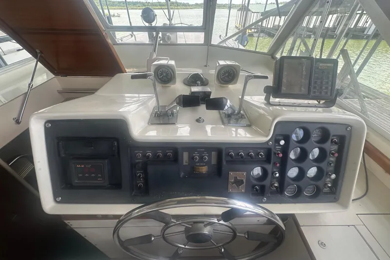 Slide: The Image of 1971 Chris-Craft Commander 42 helm with gauges and controls, overlooking marina. - 58