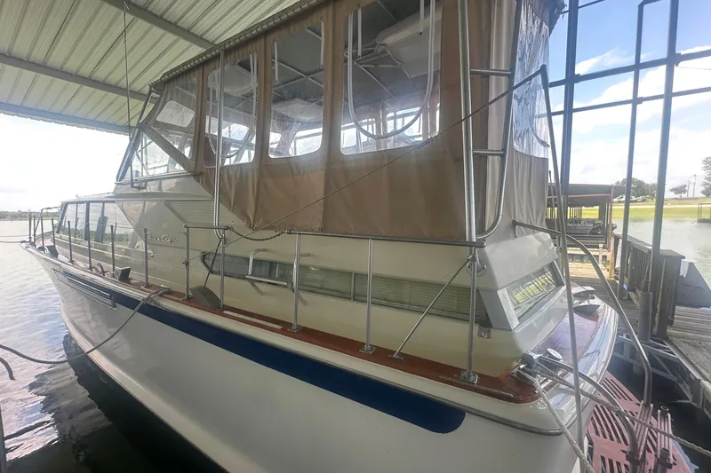 Slide: The Image of 1971 Chris-Craft Commander 42 docked under a covered marina, featuring a beige canopy. - 6