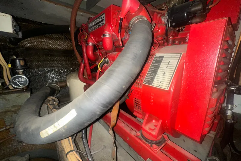 Slide: The Image of Engine compartment of a 1971 Chris-Craft Commander 42, featuring a red engine and hoses. - 63