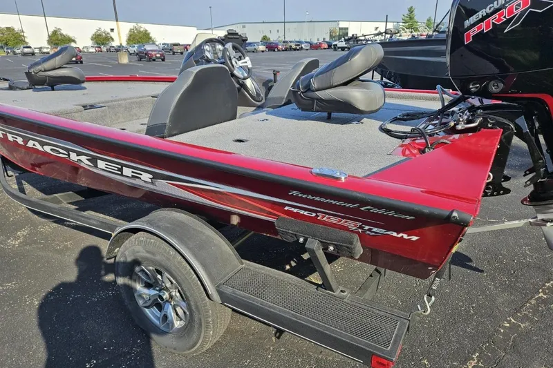 Slide: The Image of 2023 Bass Tracker 195 XTE boat, red and black, parked on a trailer in a lot. - 4