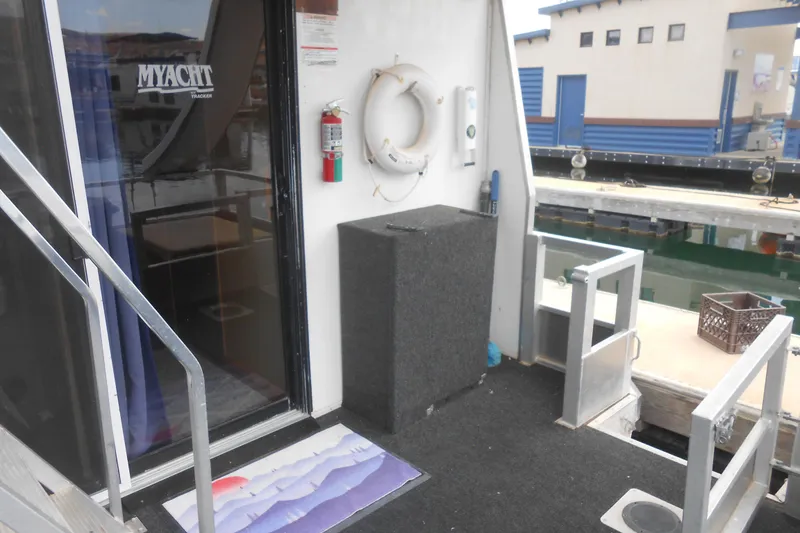 Slide: The Image of 2004 Myacht 4815 houseboat entrance with dock view and safety equipment. - 12