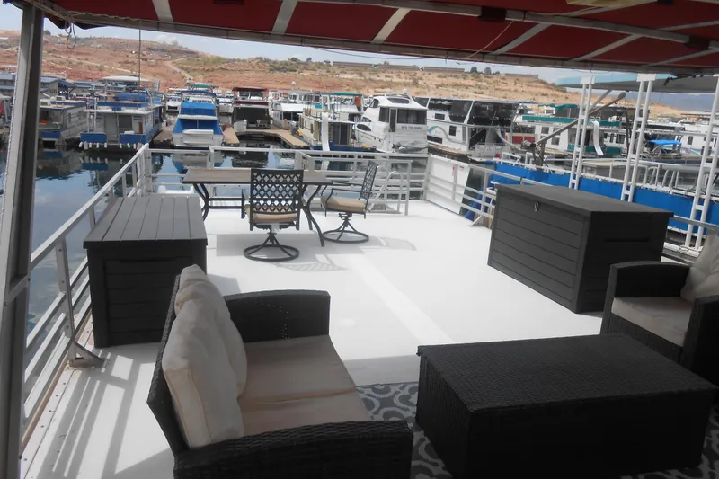 Slide: The Image of Spacious deck of 2004 Myacht 4815 houseboat with outdoor seating and marina view. - 17