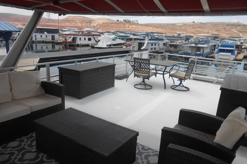 Slide: The Image of Spacious deck of 2004 Myacht 4815 houseboat with outdoor seating and marina view. - 18