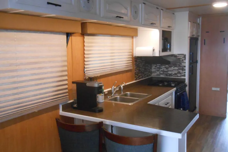 Slide: The Image of Interior of 2004 Myacht 4815 houseboat kitchen with modern appliances and wood accents. - 2