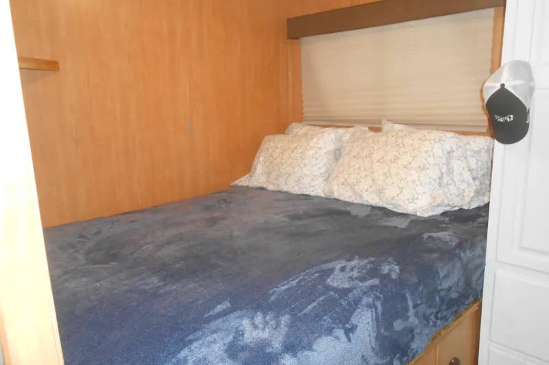 Slide: The Image of Cozy bedroom in 2004 Myacht 4815 with blue bedding and wooden walls. - 5