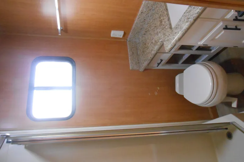 Slide: The Image of Bathroom interior of 2004 Myacht 4815 with granite countertop and window. - 7