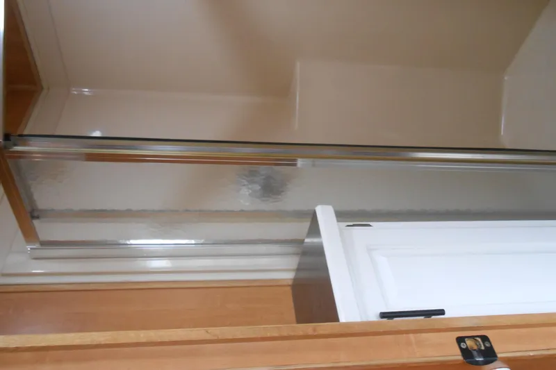 Slide: The Image of Interior of 2004 Myacht 4815 showing a shower with glass door and white cabinet. - 8