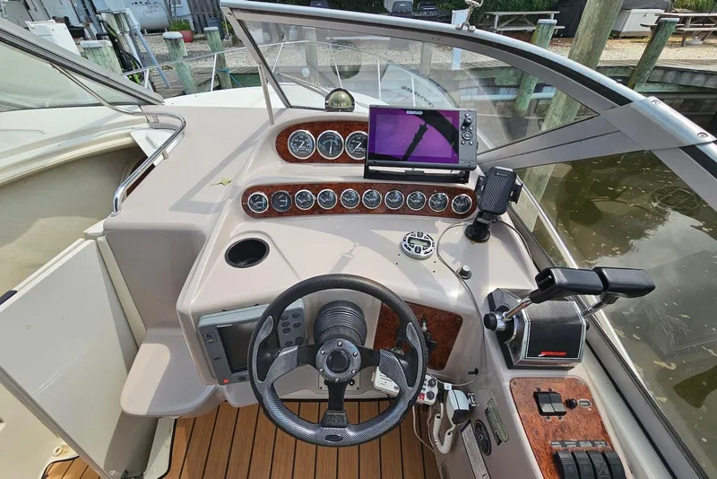 Slide: The Image of Cockpit of 1999 Regal Commodore 292 boat with steering wheel and control panel. - 11