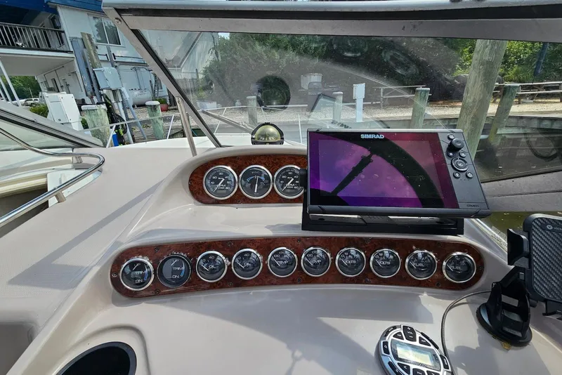 Slide: The Image of 1999 Regal Commodore 292 boat dashboard with gauges and Simrad navigation system. - 13