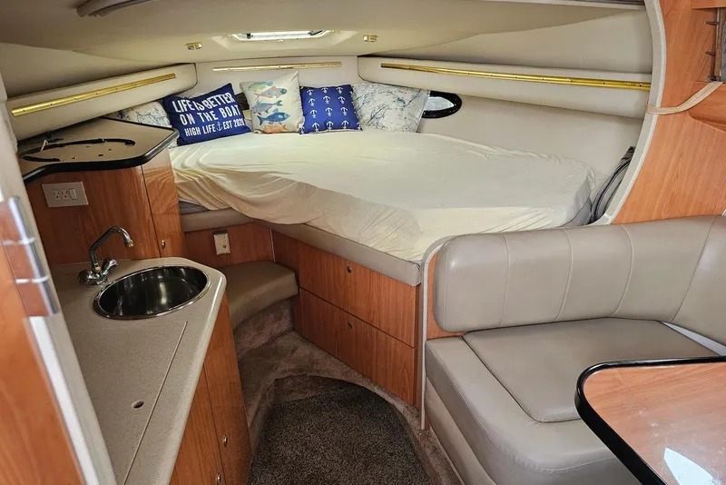 Slide: The Image of Cozy interior of 1999 Regal Commodore 292 boat with bed, sink, and seating area. - 22