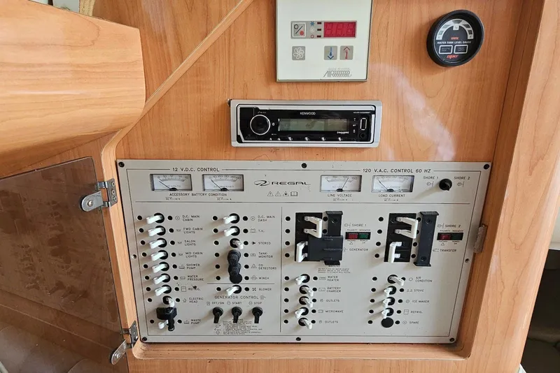 Slide: The Image of Control panel of a 1999 Regal Commodore 292 boat with switches and gauges. - 25