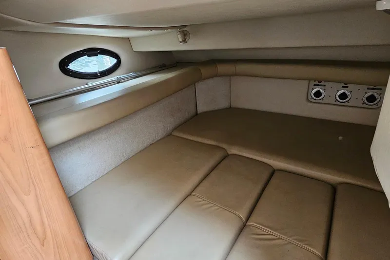 Slide: The Image of 1999 Regal Commodore 292 cabin interior with beige seating and porthole window. - 27