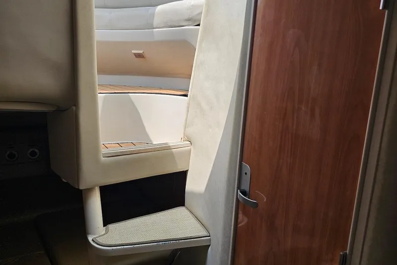 Slide: The Image of Interior of 1999 Regal Commodore 292 boat, featuring steps and a wooden door. - 28